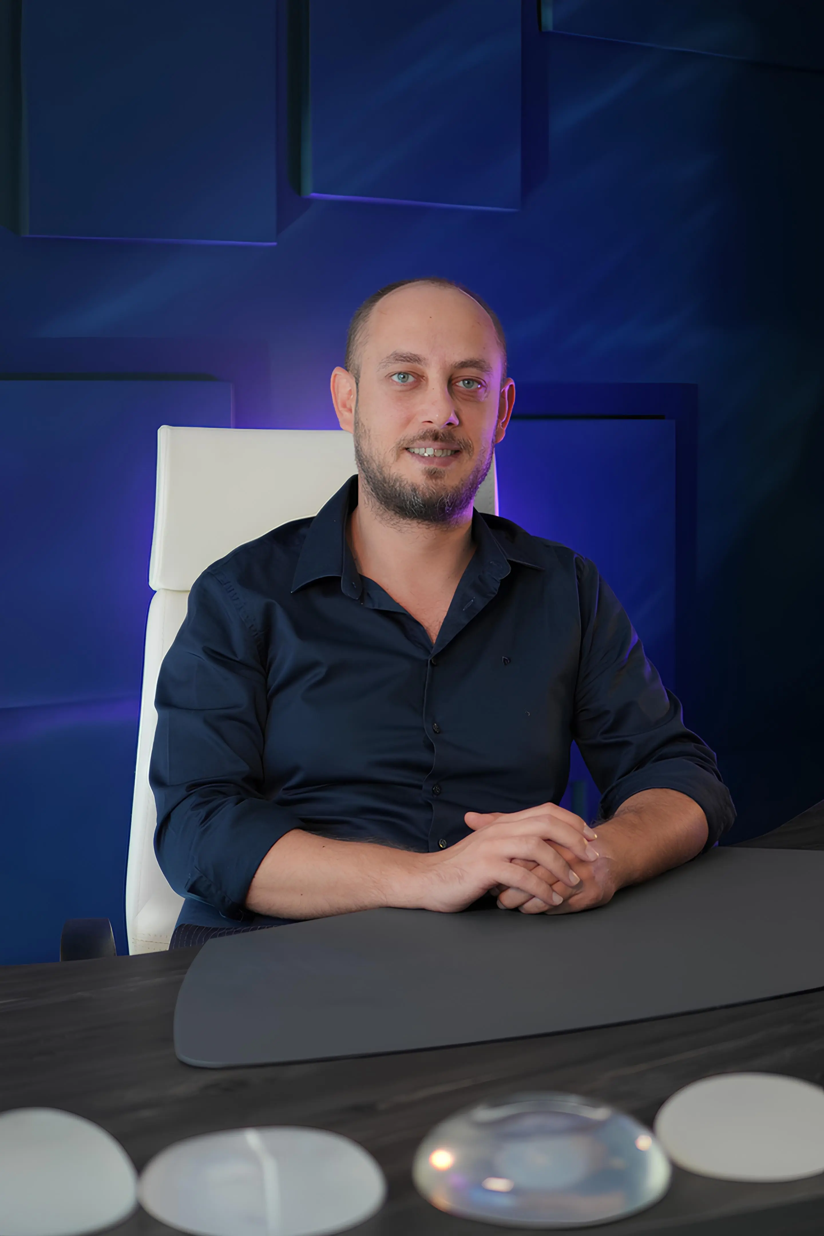 Dr. Mert Meral, arms crossed, in his Lara clinic